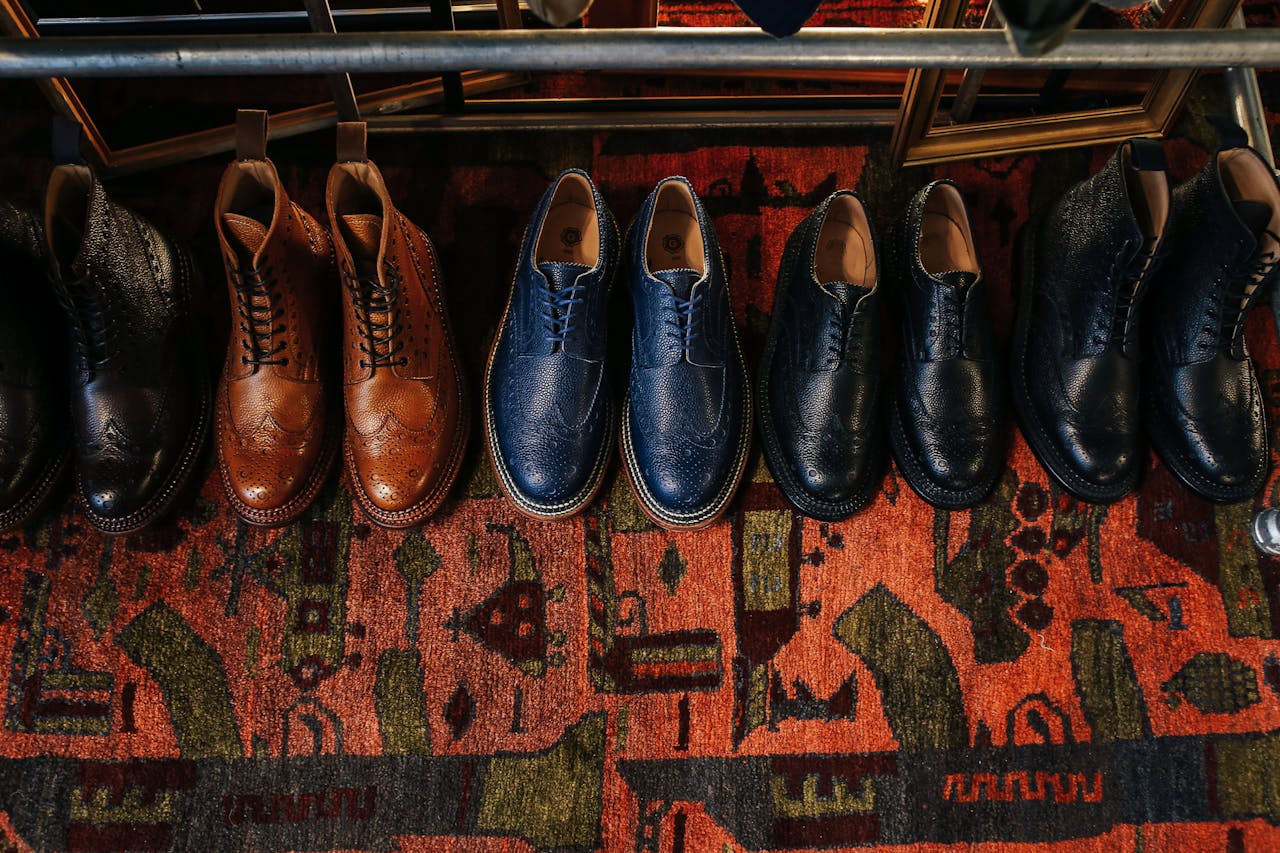 A collection of classic leather shoes displayed on a colorful vintage carpet, showcasing elegant fashion.