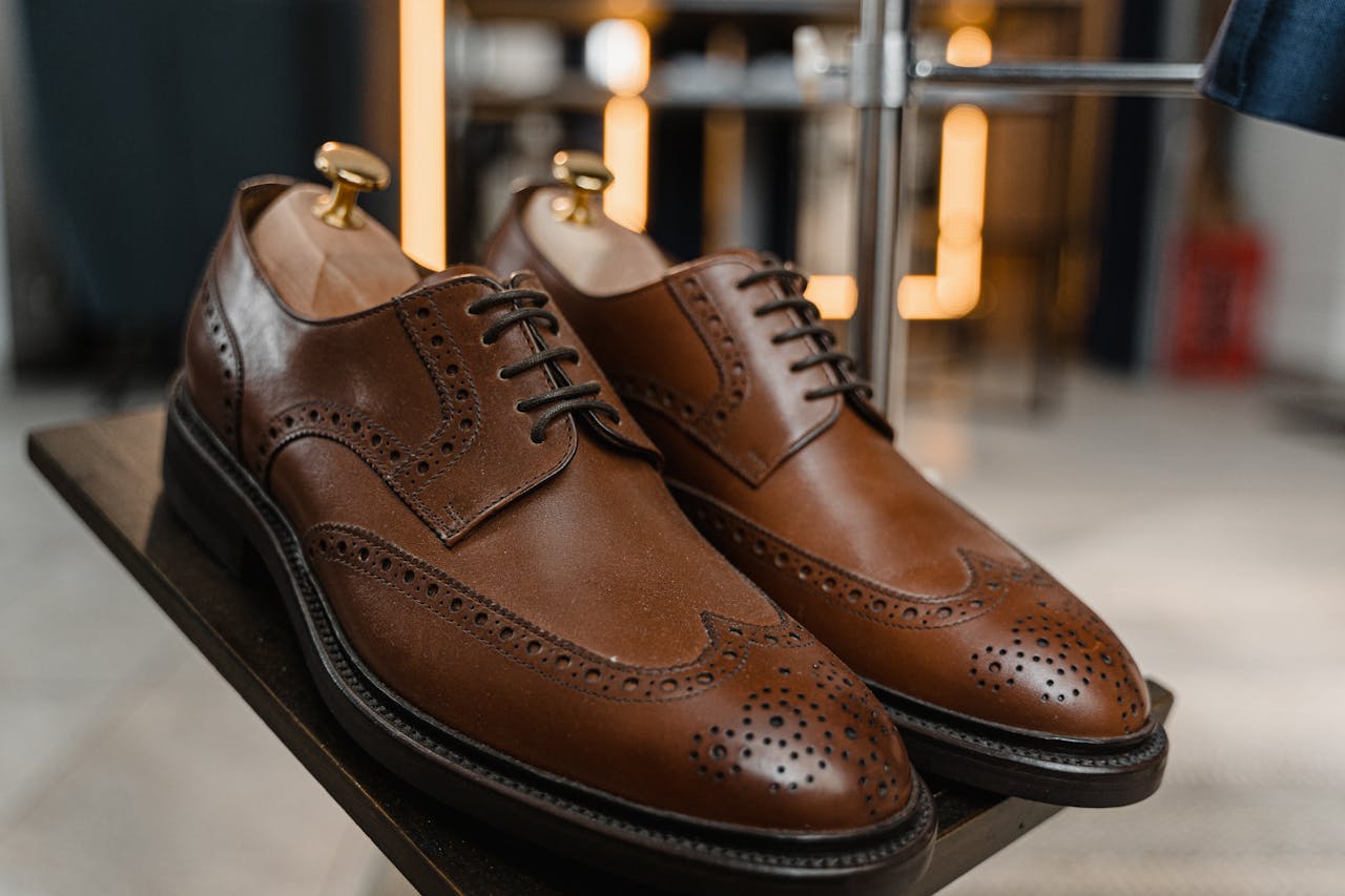 services-02 Classic brown leather brogue shoes with detailed perforations on a stylish display.