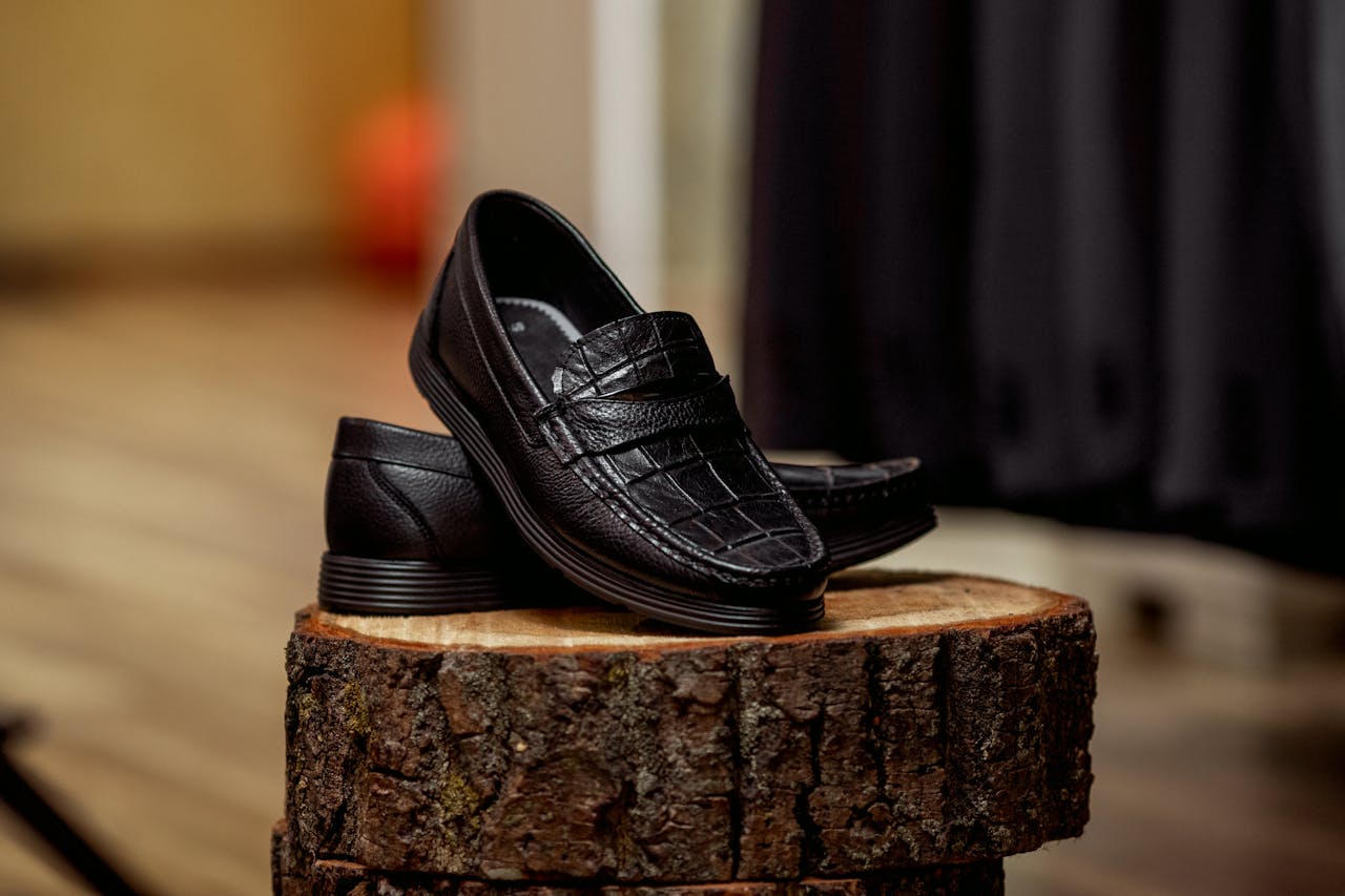 services-01 Stylish black loafers displayed on wood, highlighting detailed craftsmanship.